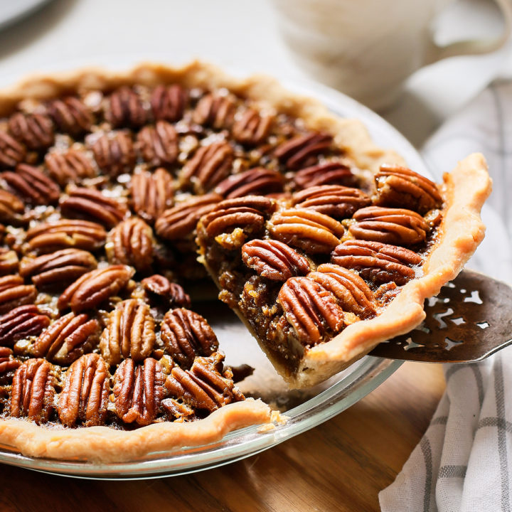 slice of bourbon pecan pie being served from a pie plate