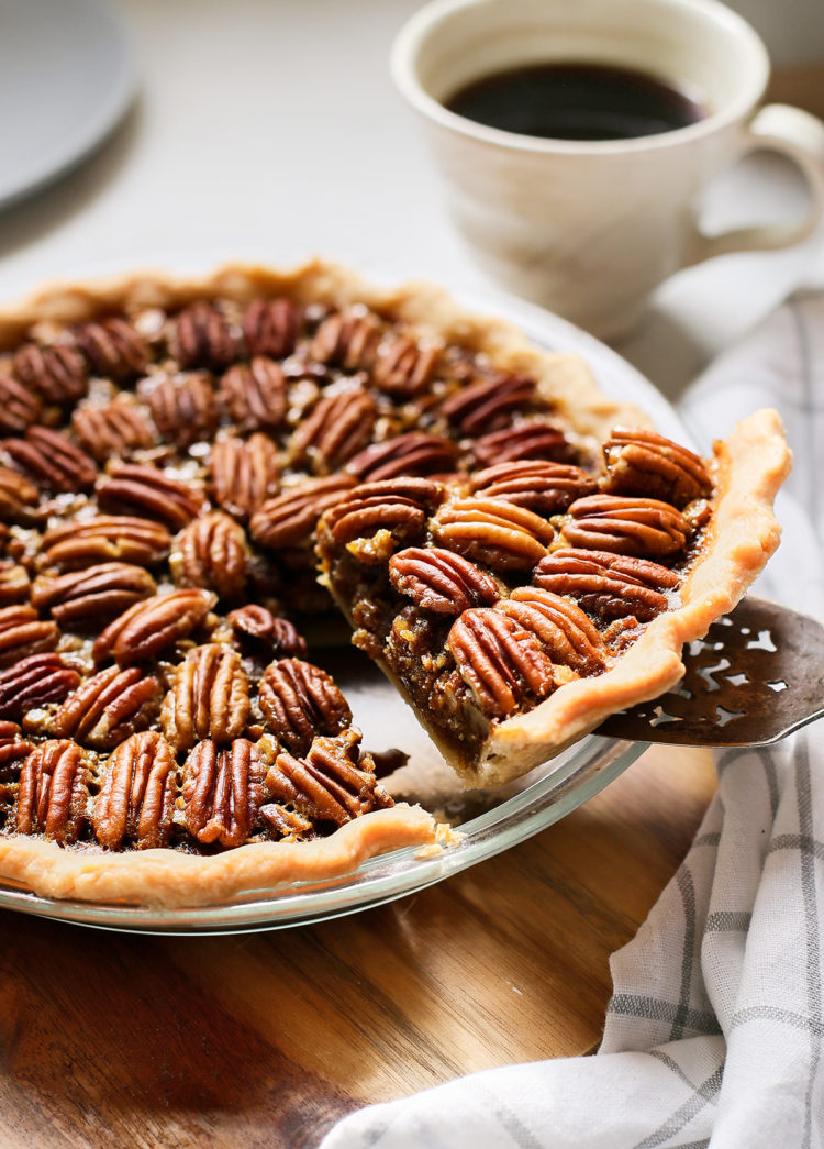 slice of bourbon pecan pie being served from a pie plate