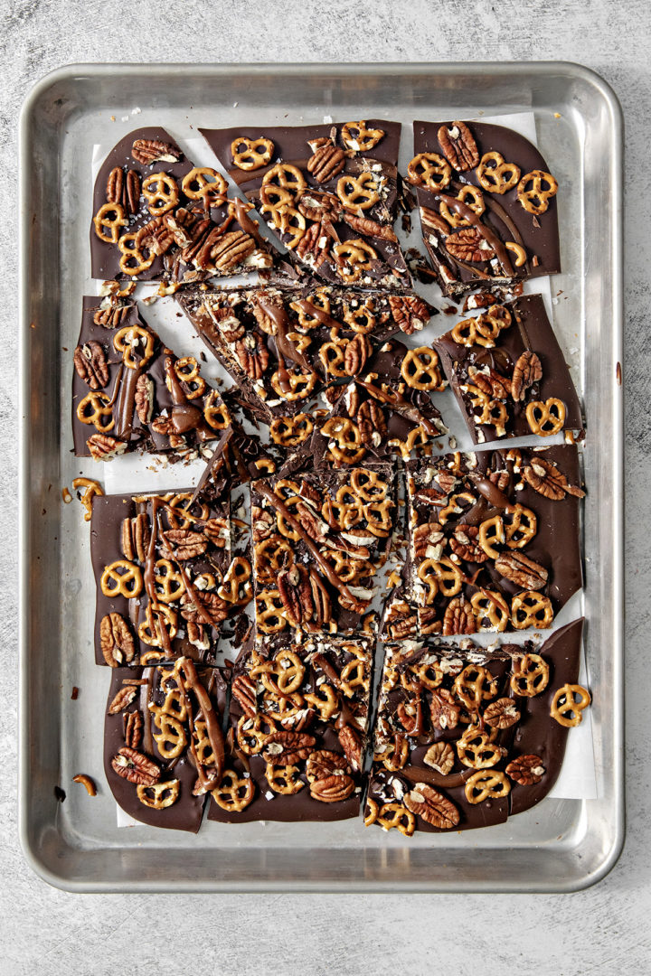 pieces of dark chocolate pretzel bark on a baking sheet