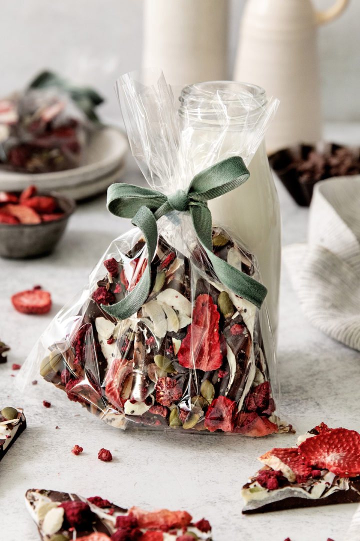 a gift bag with dark chocolate fruit and nut bark in it