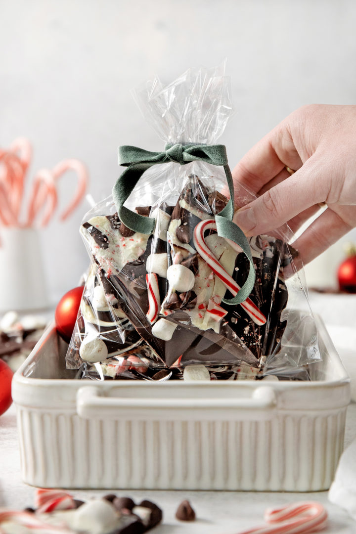 woman holding a gift bag of chocolate peppermint bark for homemade holiday gifts