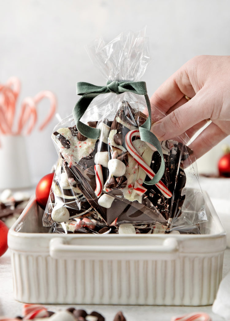 woman holding a gift bag of chocolate peppermint bark for homemade holiday gifts