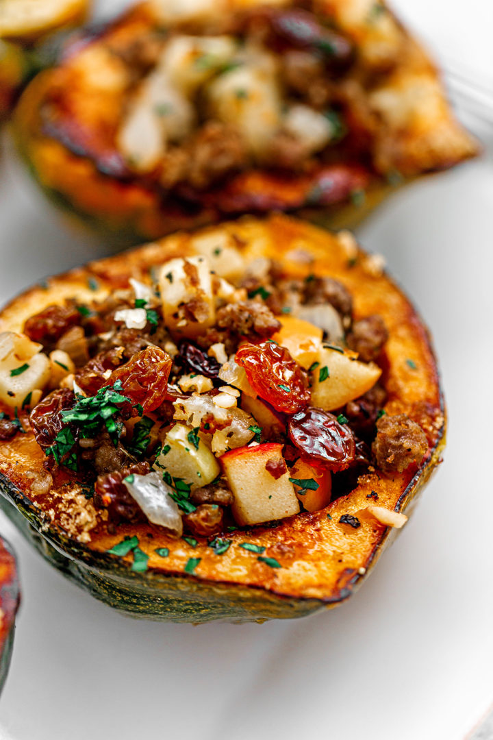 close up photo of an acorn squash stuffed with sausage and apples