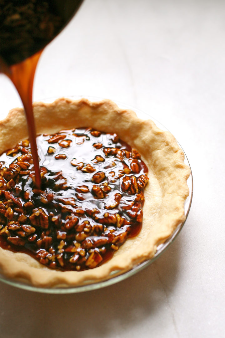 photo of bourbon pecan pie filling being poured into a pie shell