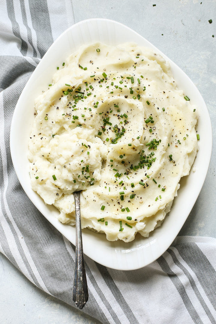 overhead photo of healthy mashed potatoes made with greek yogurt in a white serving bowl