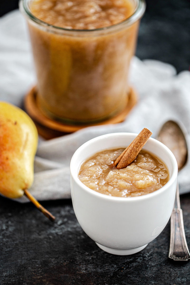 a serving of pear sauce in a white bowl with a spoon