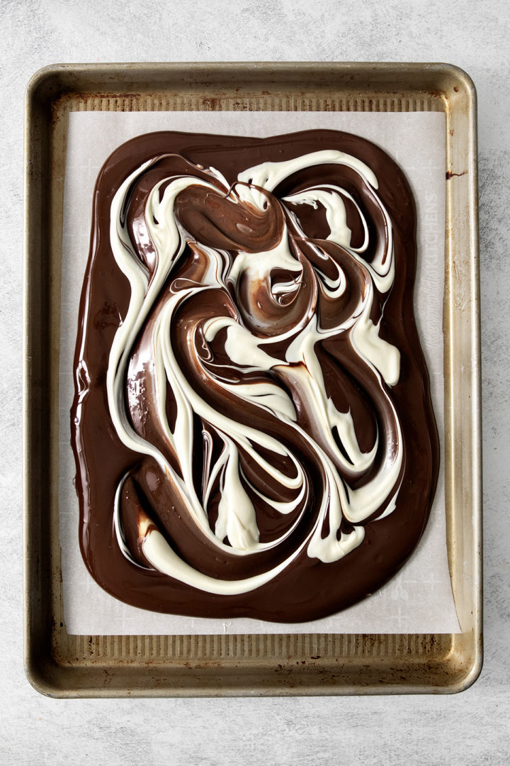 dark and white chocolate swirled together on a baking pan for making nut and fruit chocolate bark