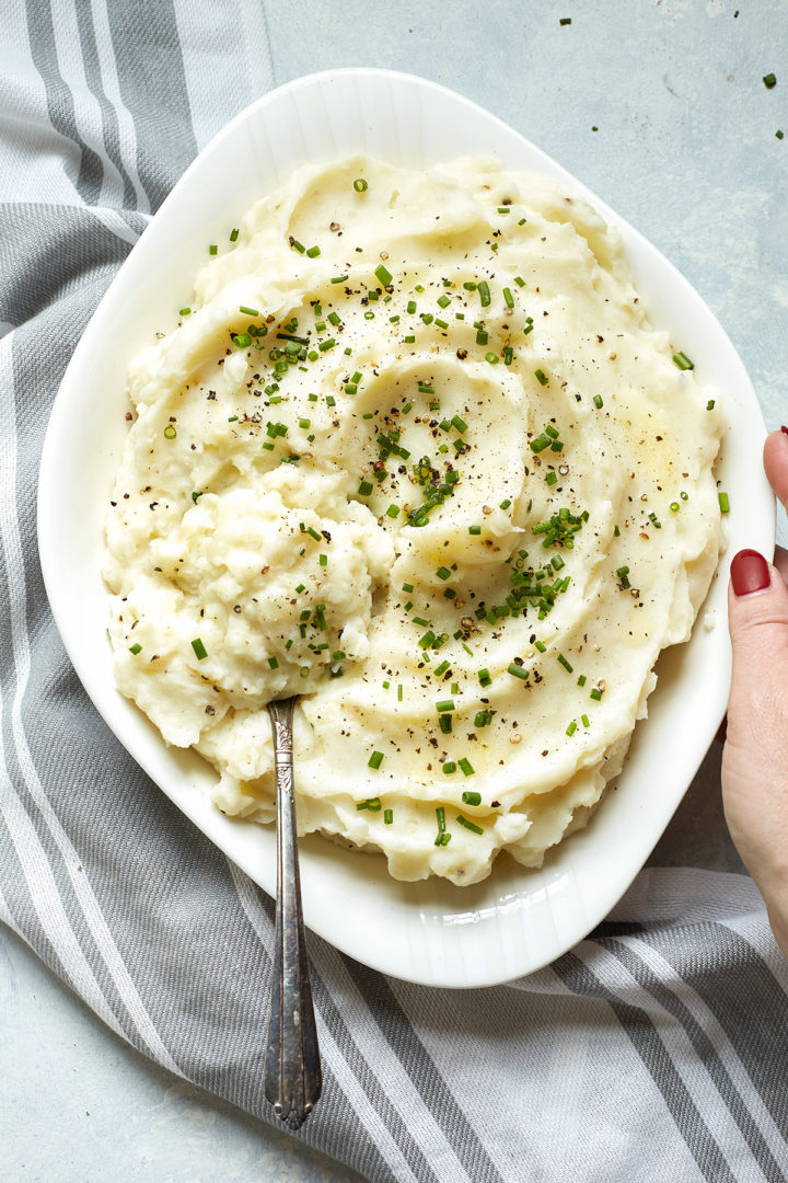 woman setting a bowl of greek yogurt mashed potatoes on the table