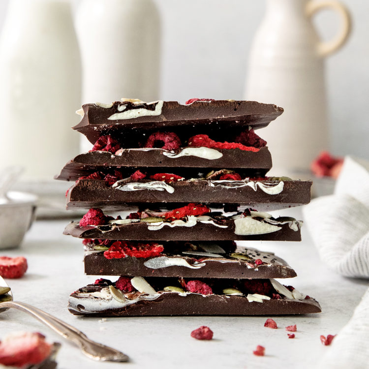 a stack of fruit and nut chocolates on a white background