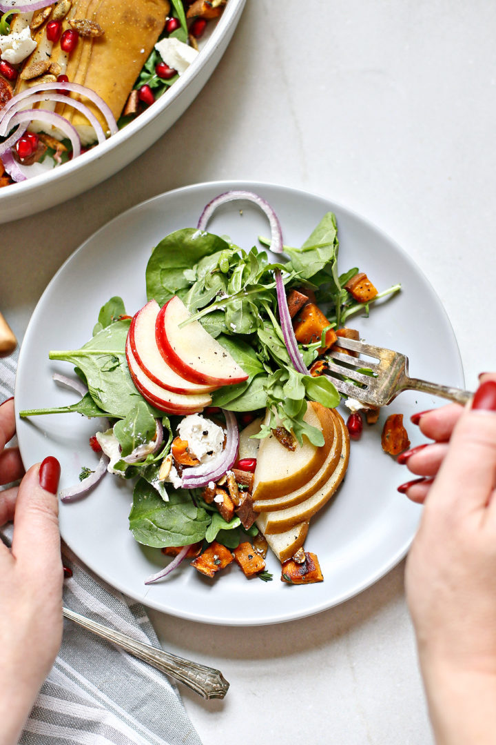 woman eating a fall pear salad with spinach