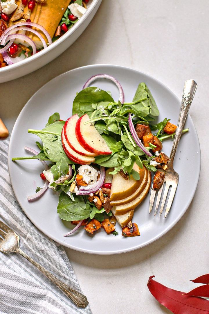 pear arugula salad on a grey plate with a fork