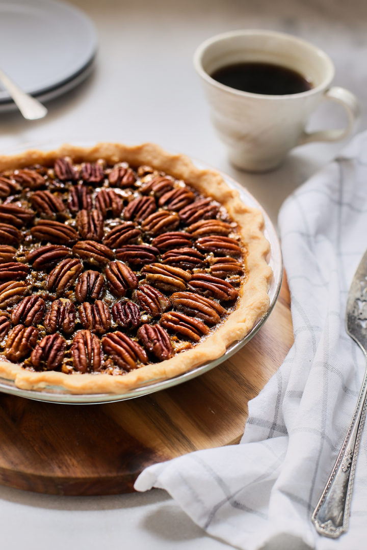 the best bourbon pecan pie on a wooden trivet on a table