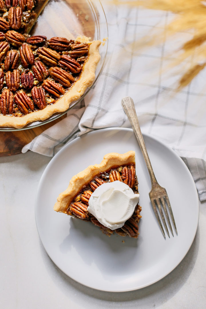 overhead photo of a slice of pecan bourbon pie on a grey plate with a vintage fork