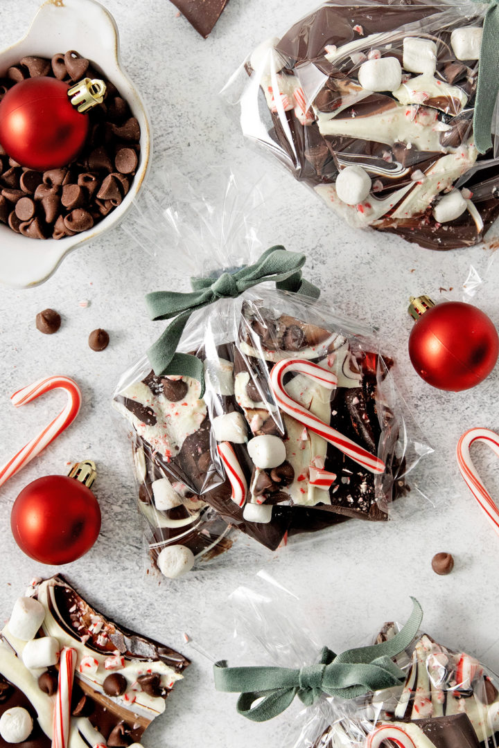 overhead photo of gift bags with green velvet ribbon that are filled with this easy peppermint bark recipe