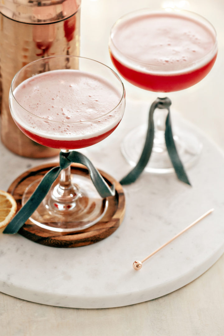 close up of two cranberry orange whiskey cocktails in coupe glasses