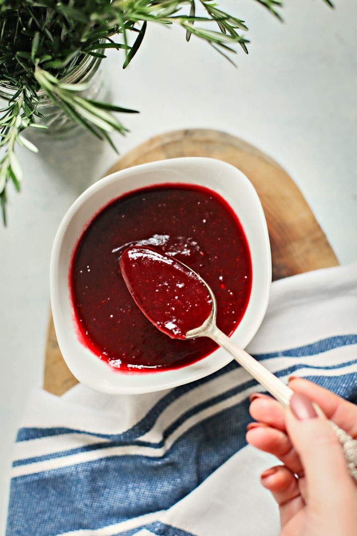 woman stirring a bowl of cranberry sauce made with red wine