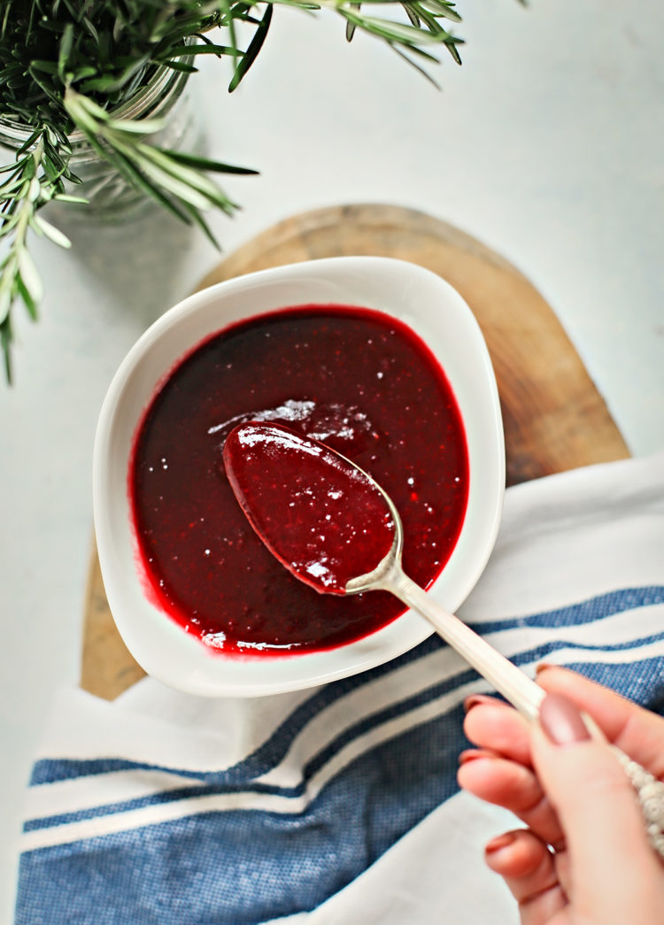 woman stirring a bowl of cranberry sauce made with red wine