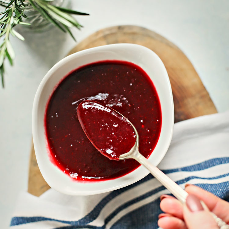 woman stirring a bowl of cranberry sauce made with red wine