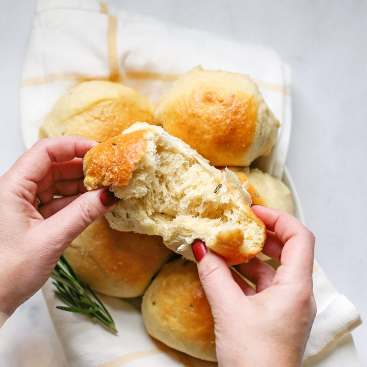 woman holding a rosemary potato roll