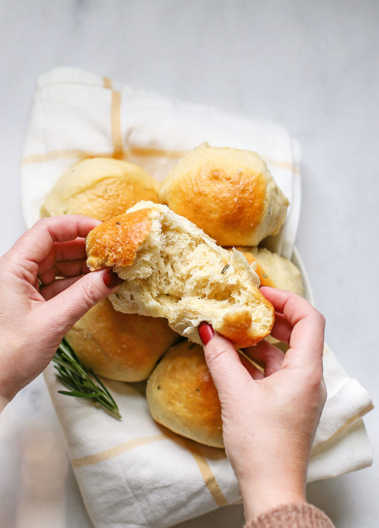 woman holding a rosemary potato roll