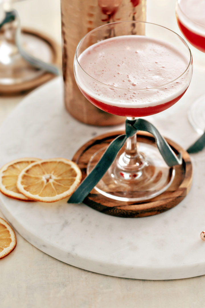 close up photo of a cranberry orange whiskey sour served in a coupe glass