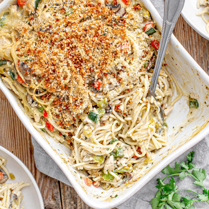 overhead photo of a turkey tetrazzini recipe baked in white casserole dish