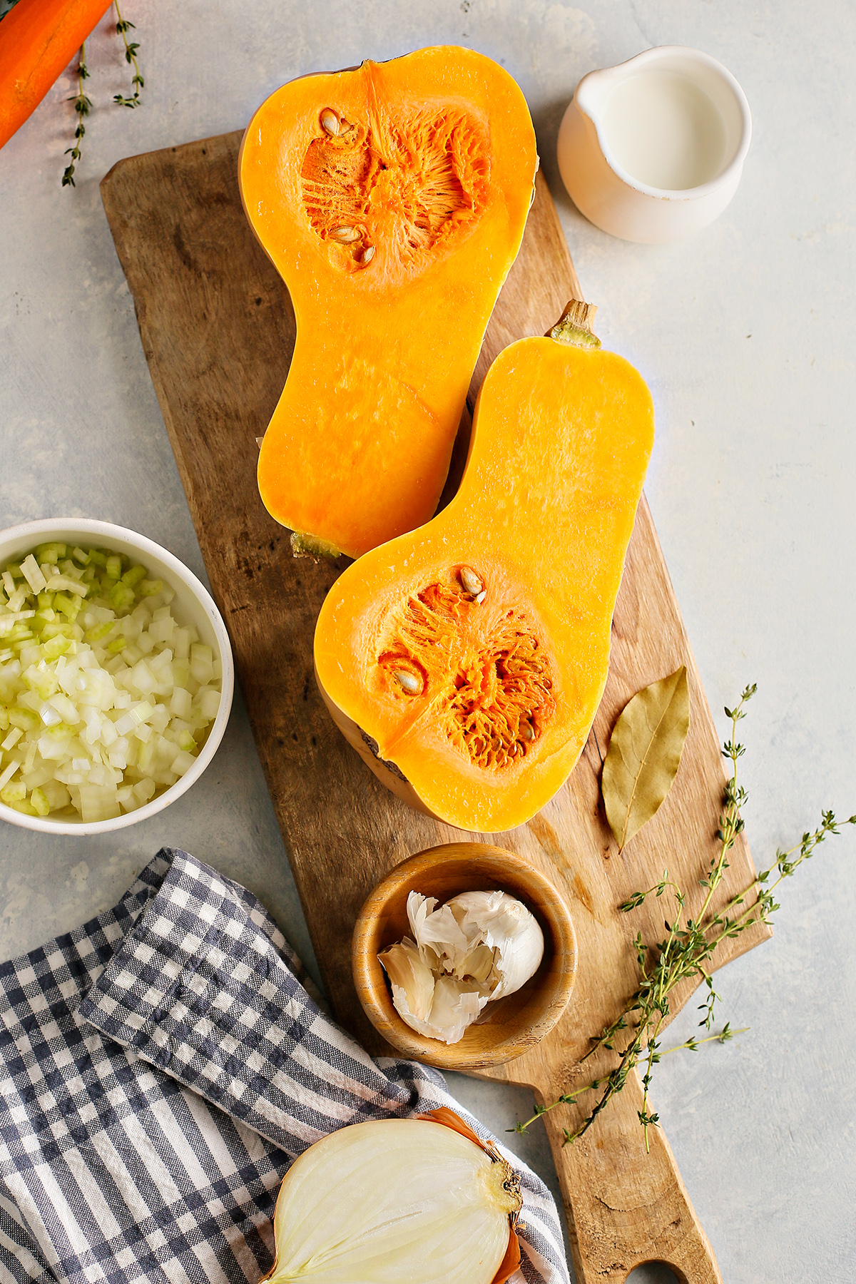 ingredients needed to make butternut apple soup on a cutting board