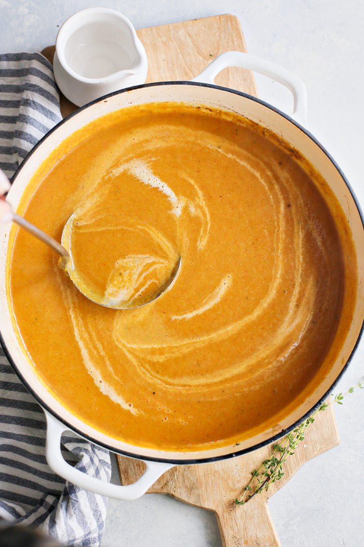 woman stirring a pot of butternut squash and apple soup	