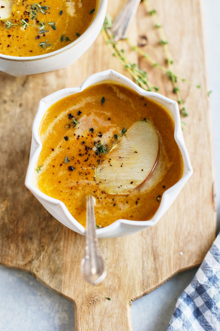 bowl of butternut squash soup with apple slice garnish