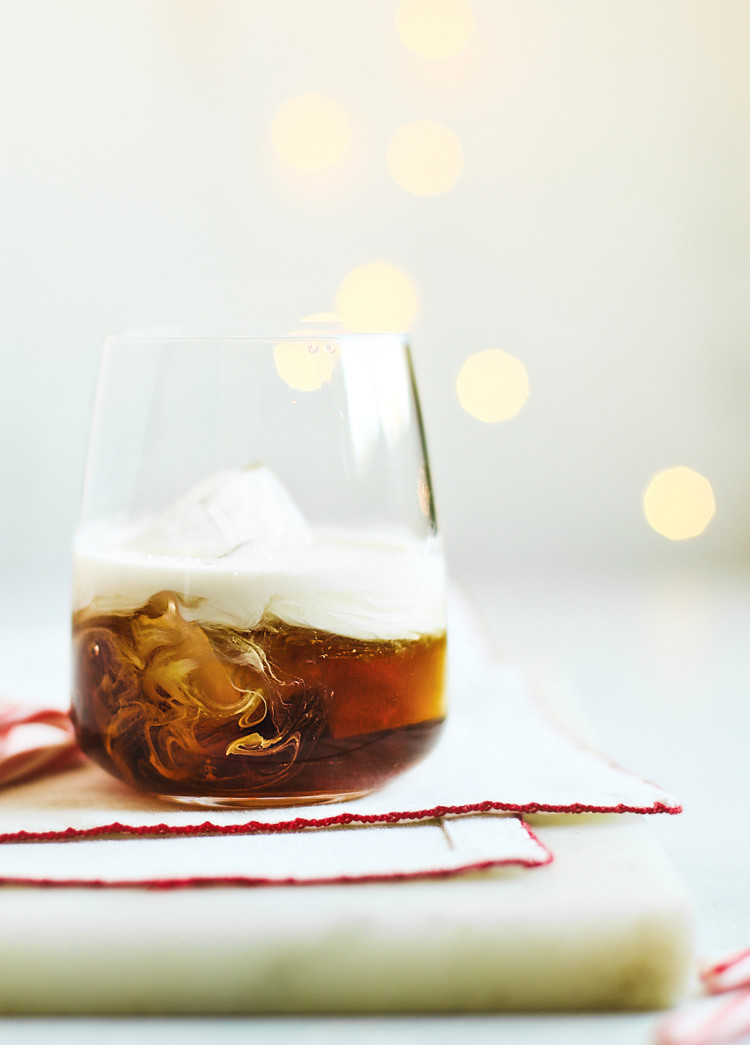 peppermint white russian in a glass with christmas lights in the background