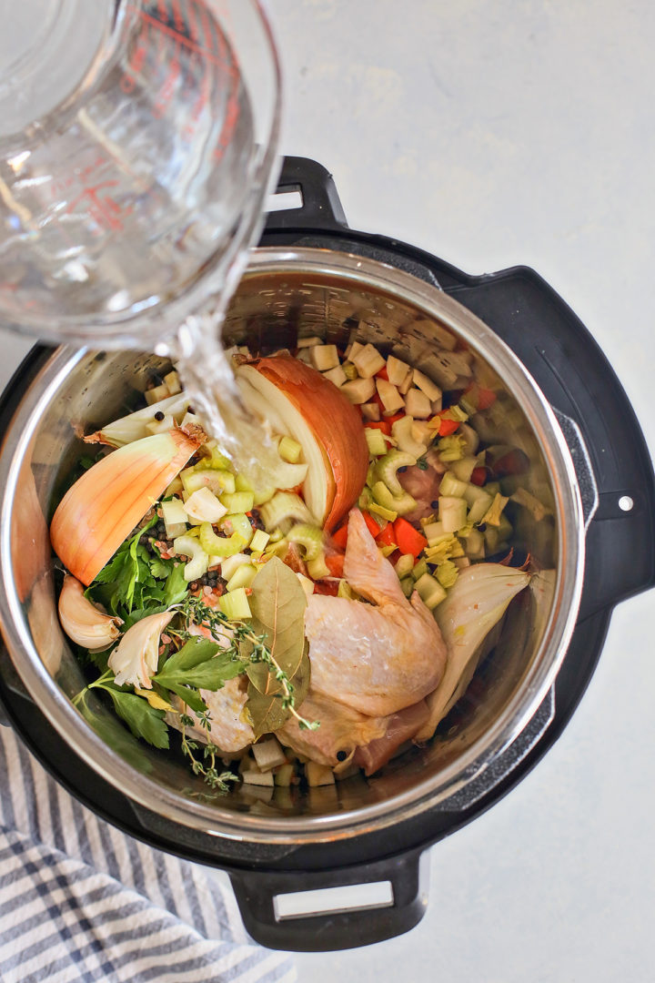 adding water to the instant pot for homemade chicken stock recipe