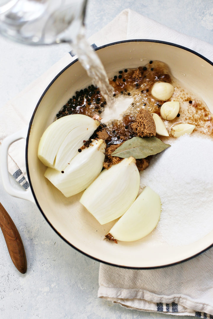 adding water to ingredients for a brine for pork shoulder