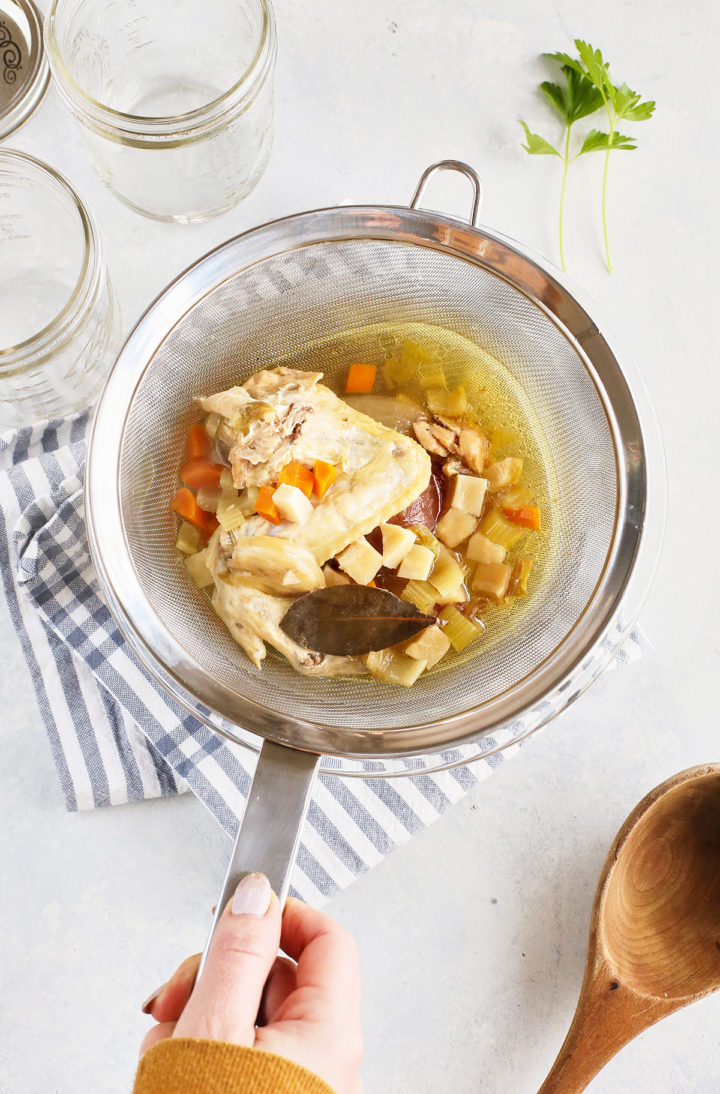 woman straining homemade chicken stock cooking in the instant pot