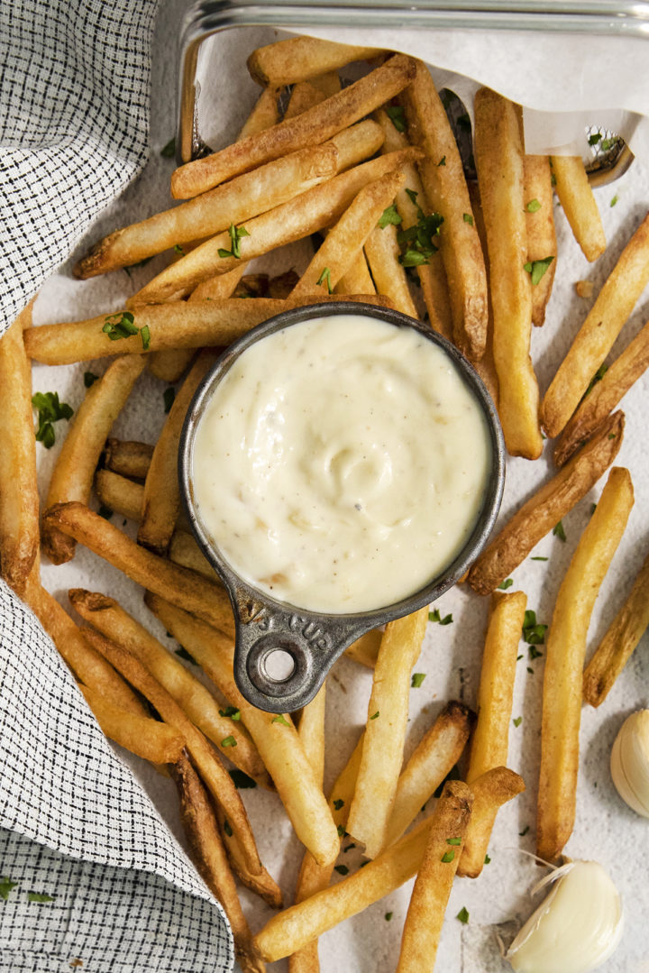 overhead photo of french fries with a bowl of garlic aioli dipping sauce