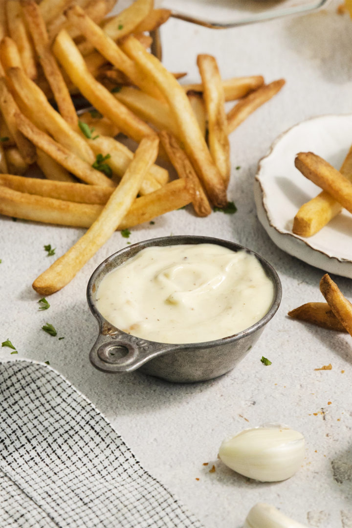 roasted garlic aioli in a metal bowl next to french fries