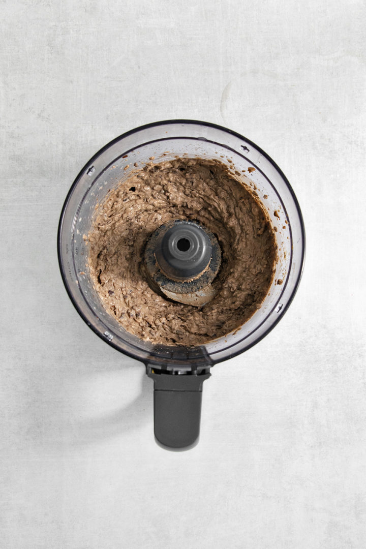 showing black bean hummus pureed in a food processor