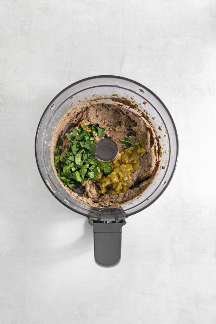 stirring fresh cilantro and green chiles into a black bean hummus recipe