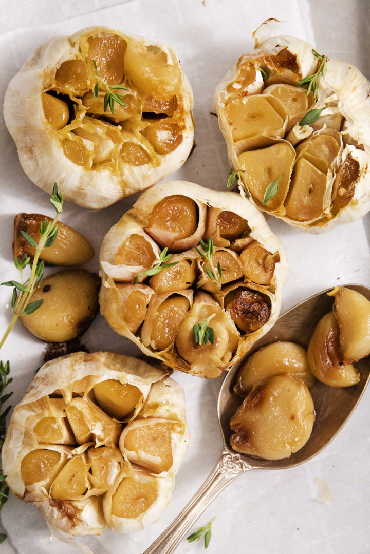 overhead photo of whole roasted garlic bulb with fresh thyme