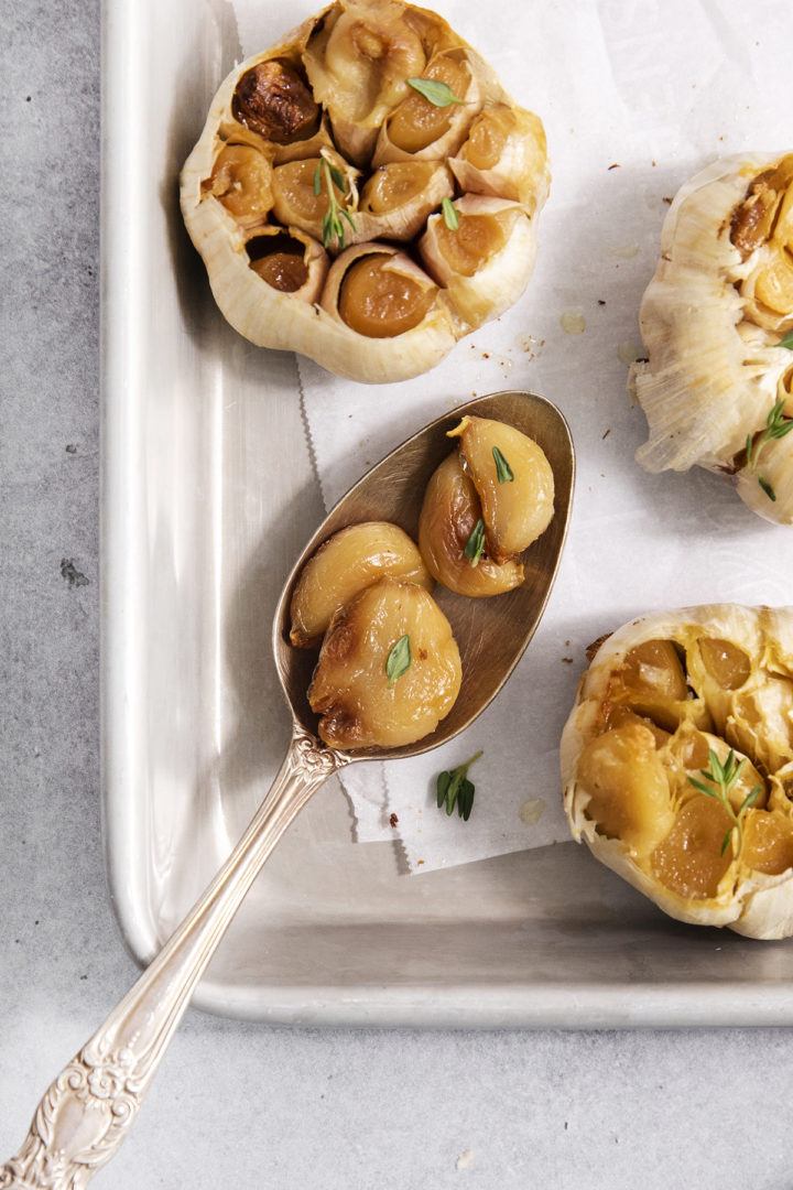 a spoon with roasted garlic cloves