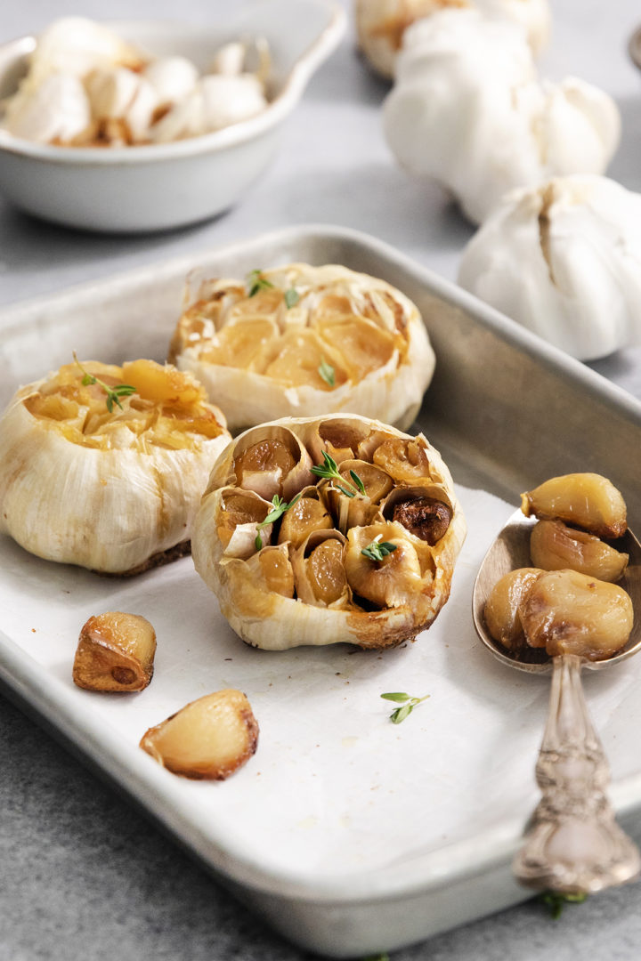 heads of roasted garlic after cooking on a baking sheet