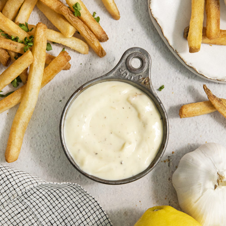 roasted garlic aioli in a metal bowl next to french fries