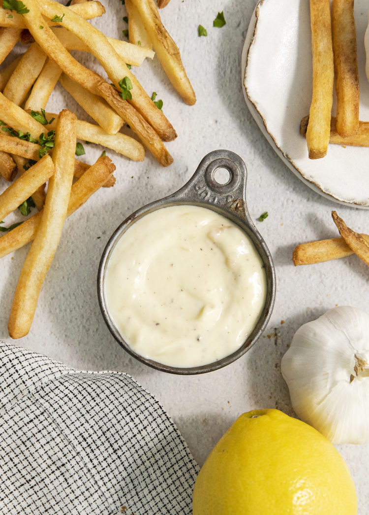roasted garlic aioli in a metal bowl next to french fries