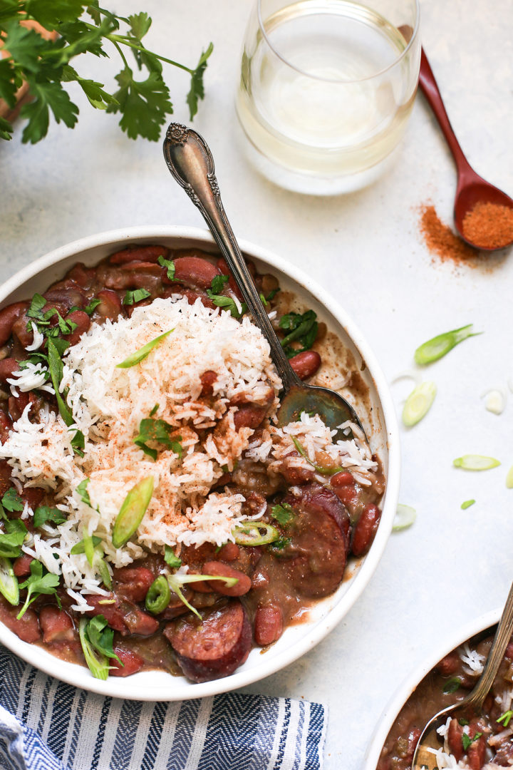 red beans and rice with andouille sausage in a white bowl with a spoon