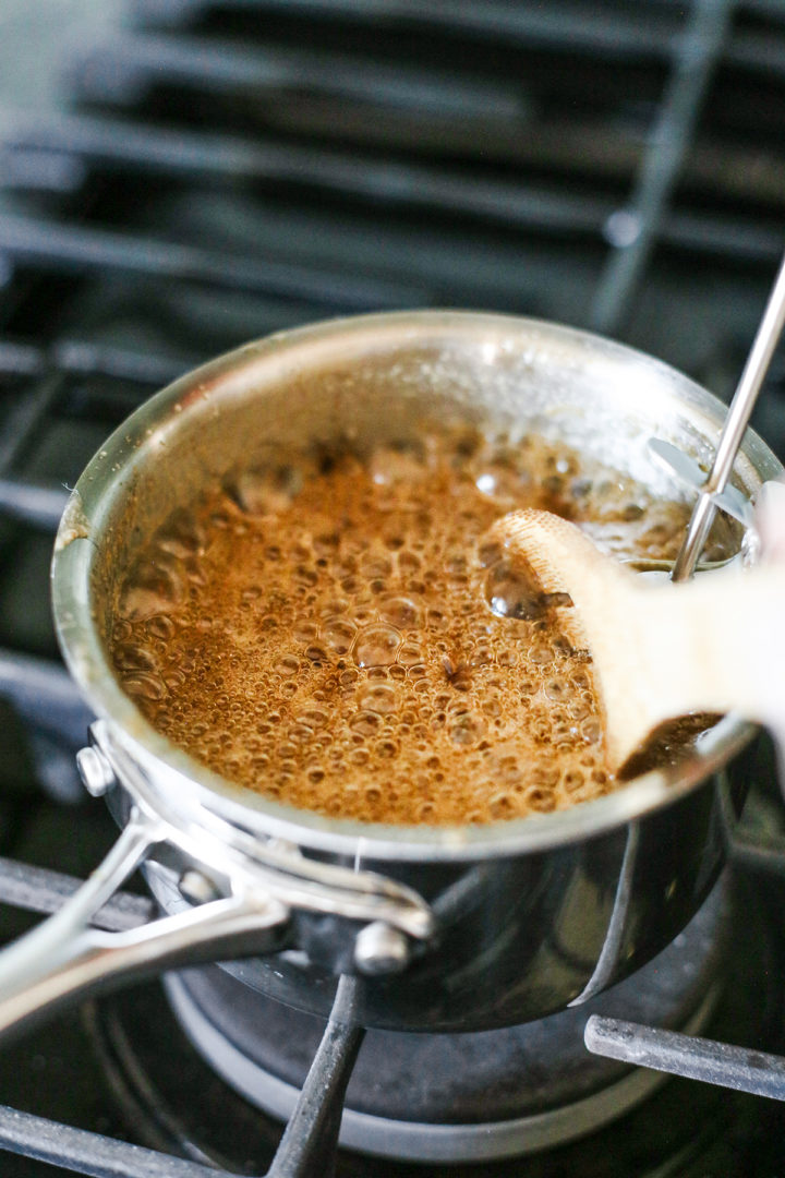 a pot of caramel frosting for this guinness brownie recipe cooking on the stove