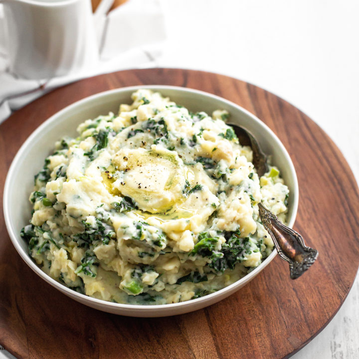 colcannon potatoes in a white bowl on a wooden tray