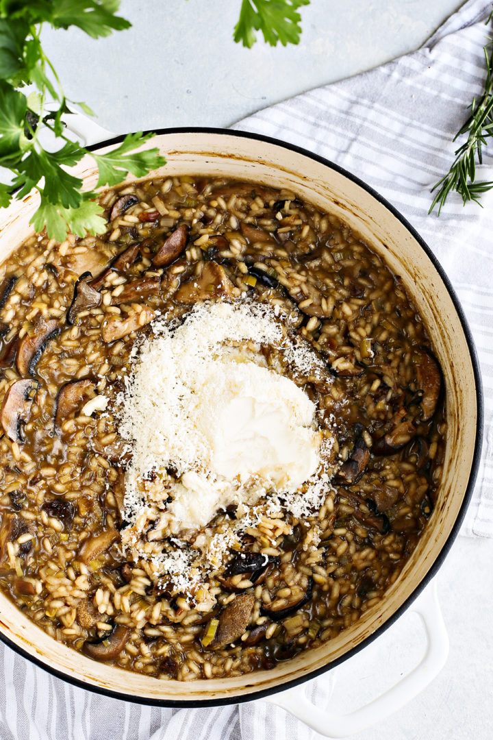 adding parmesan cheese to mushroom risotto