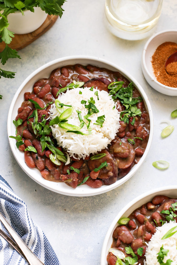 two white bowls with red beans and rice with andouille sausage 