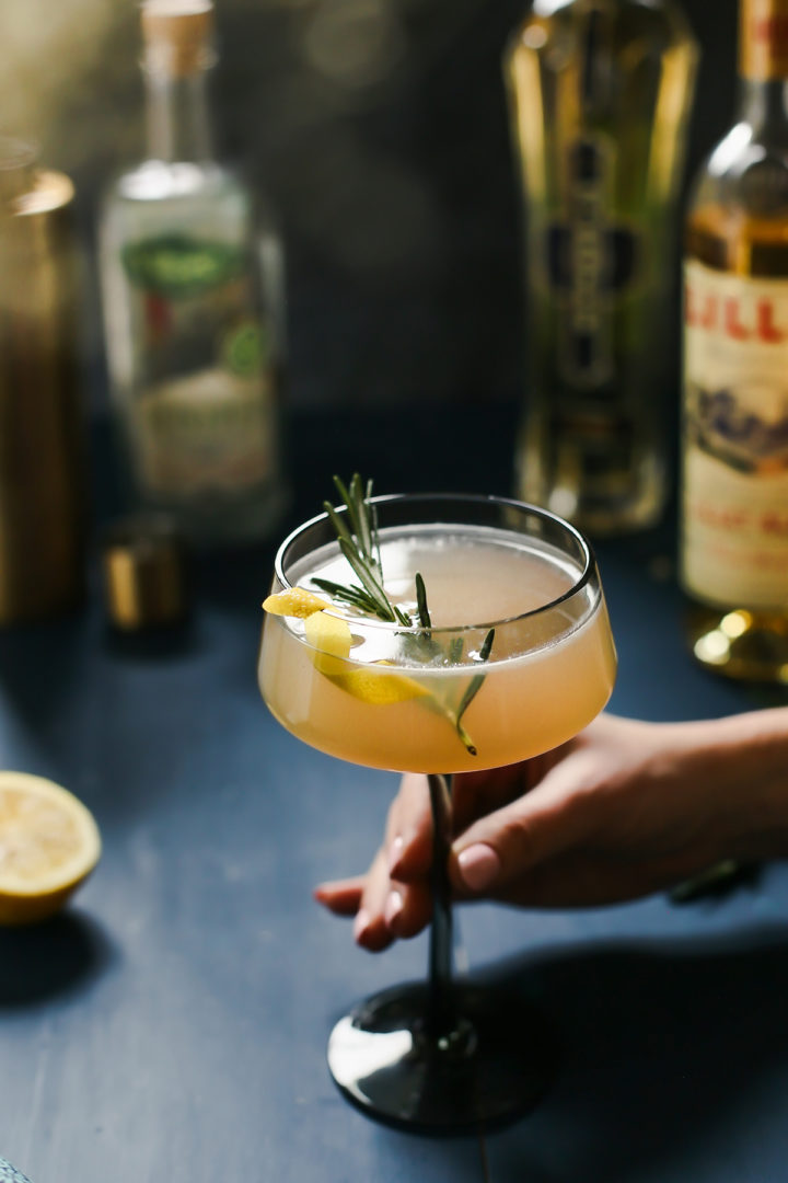 woman holding a cocktail glass containing a french blonde cocktail