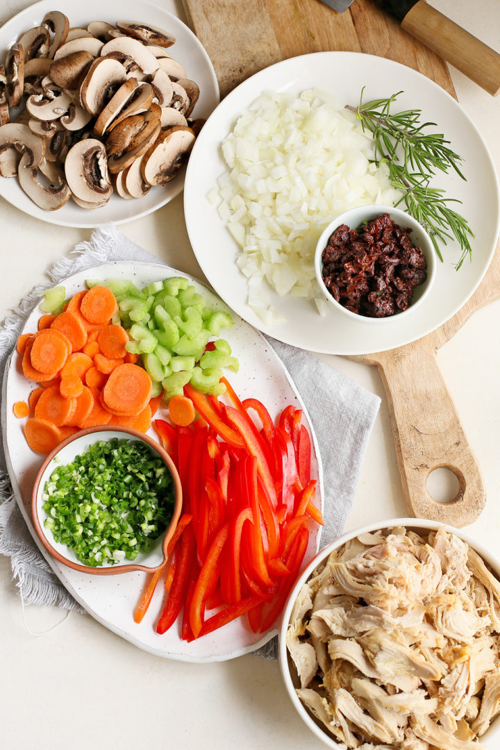 ingredients needed to make chicken mini pot pies arranged on a plate and cutting board