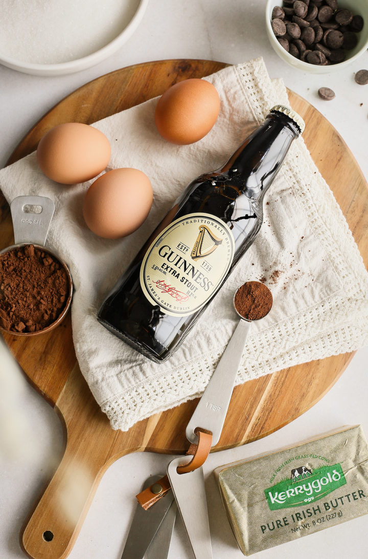 ingredients needed to make guinness brownies on a round wooden cutting board